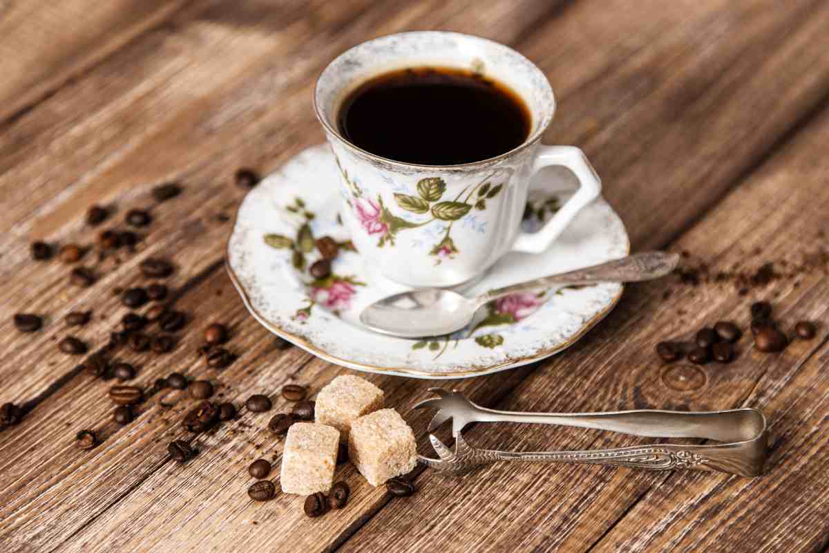 caffè in tazza d'epoca con zollette di zucchero vicino