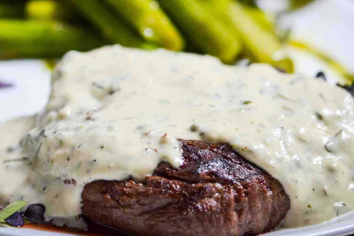 Bistecca con crema saporita in un piatto con asparagi