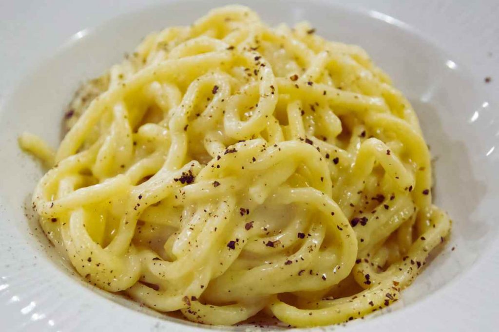 Pasta cacio e pepe, qui degli spaghetti con cremina di pecorino romano e pepe nero tostato