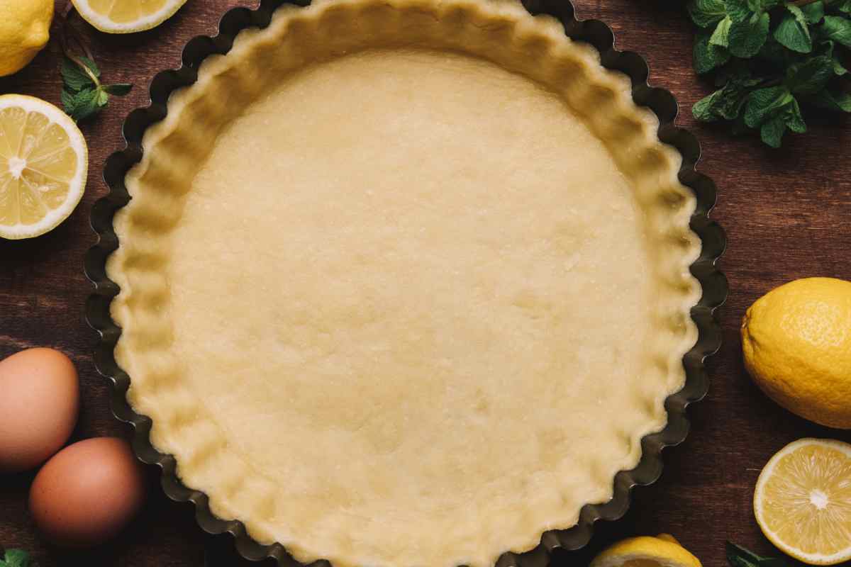 Pasta frolla con olio in uno stampo per crostate vista dall'alto