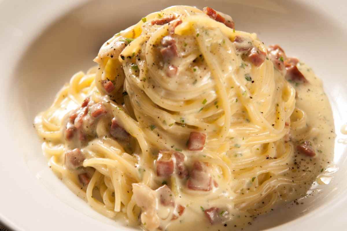 Spaghetti alla carbonara con panna in un piatto fondo