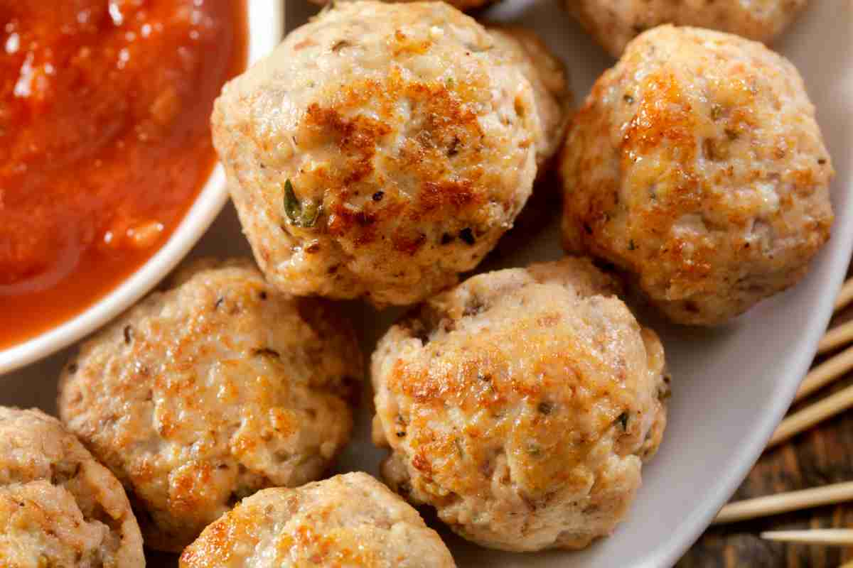 Polpette di tonno in un piatto con una ciotolina di salsa