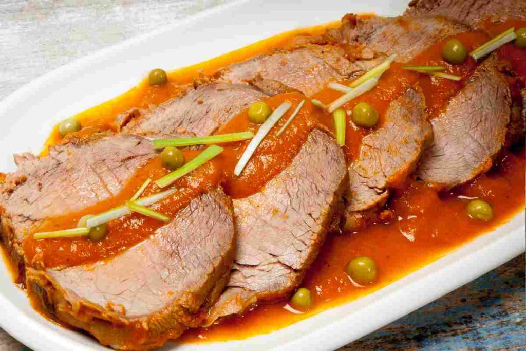 Salsa rossa su roast beef a fette in un vassoio