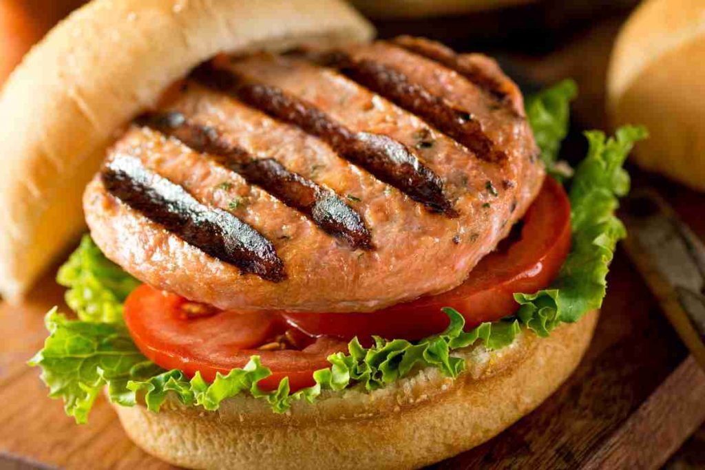 Burger di salmone grigliato in panino con pomodoro e lattuga