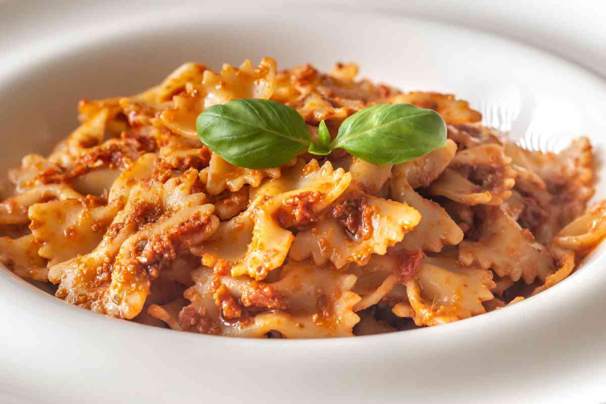 Pasta con pesto alla trapanese, questa ricetta è fatta con le farfalle e il condimento tipico siciliano a base di pomodori secchi e mandorle