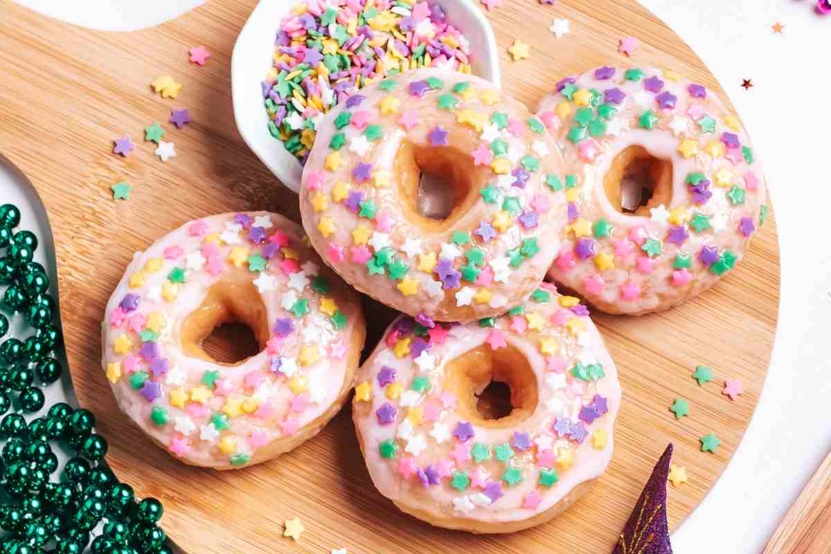 Dolci di Carnevale a forma di ciambella con zuccherini colorati