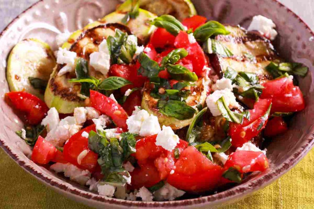 Ciotola contenente insalata greca all'italiana con pomodori zucchine e feta 