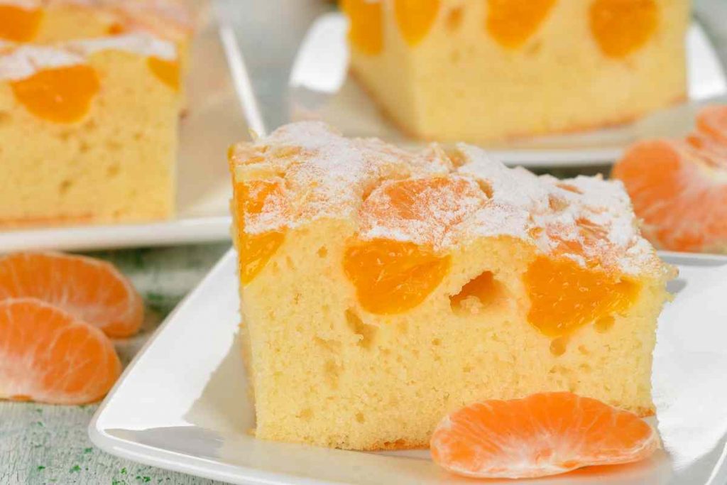 Torta al mandarino tagliata in una fetta su un piatto è una delle torte autunnali senza burro