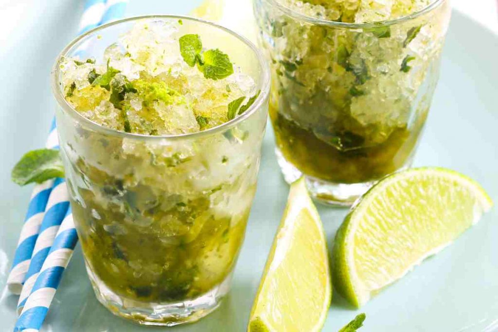 Granita Mojito in due bicchieri con menta e lime a fette