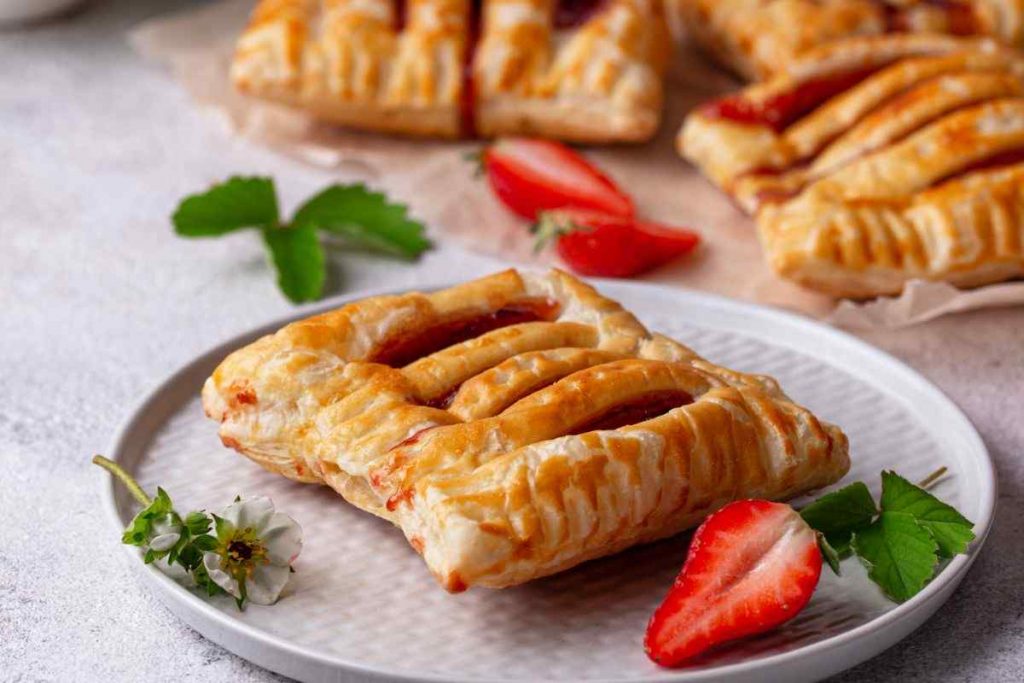 strudel di fragole su un piatto circondato da fragole