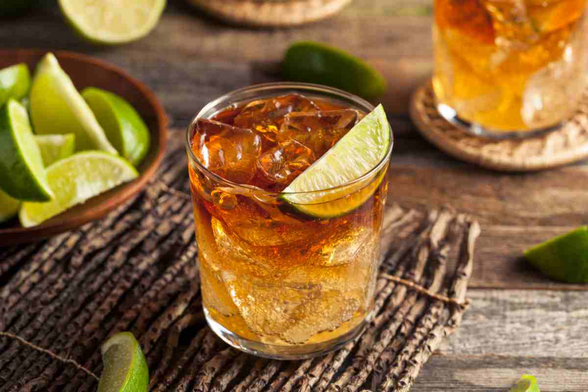 Cocktail con rum scuro e spicchio di lime a guarnire
