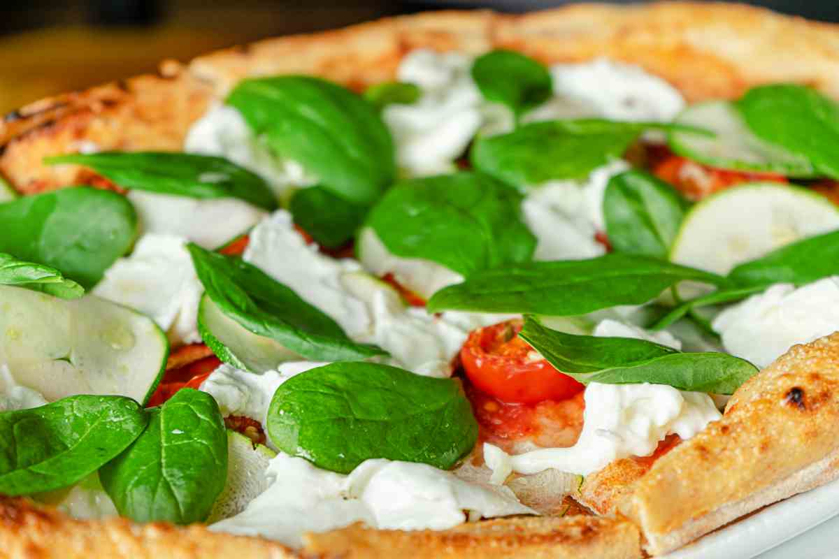 Pizza fresca stracciatella, spinacino e pomodorini è il piatto facilissimo e gustoso ideale per una cenetta con gli amici