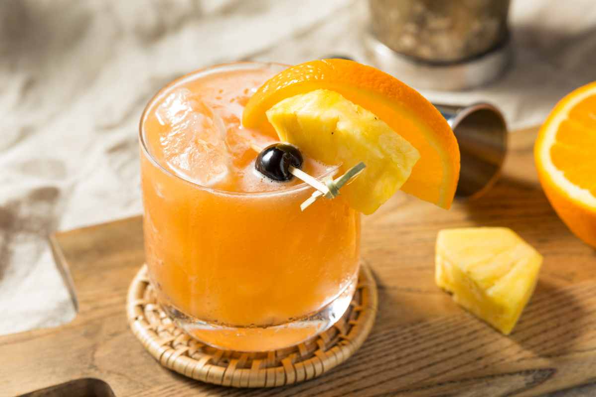 Rum Runner Cocktail in un bicchiere guarnito con arancia, ananas e ciliegia