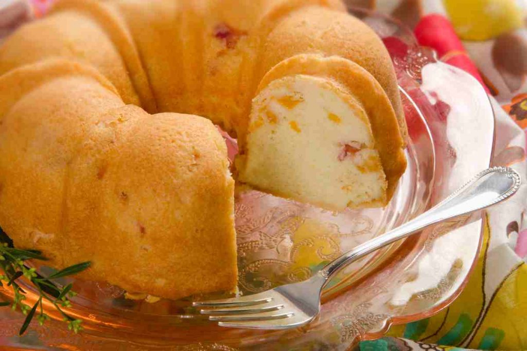 Torta nuvola con yogurt e pesche tagliata a fette su un vassoio di vetro