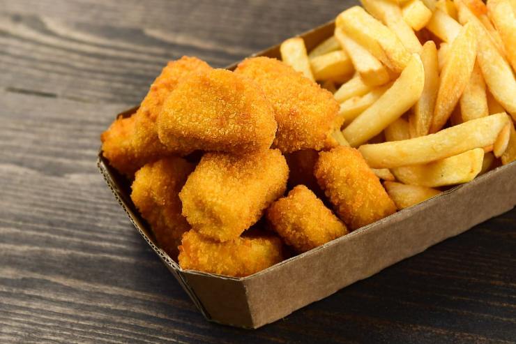 nuggets di pollo e patatine fritte in un contenitore 