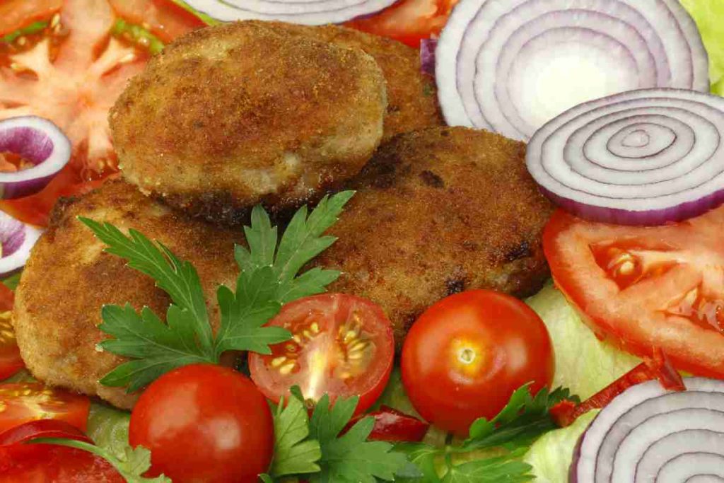 Cotolette di funghi porcini con contorno di pomodori e rondelle di cipolla