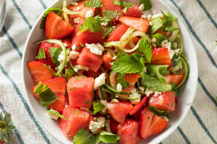 Insalata cocomero feta, fragole cetrioli e menta in una ciotola vista dall'alto