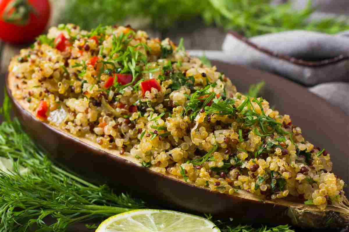 Melanzane ripiene di quinoa in un piatto guarnito con fette di limone