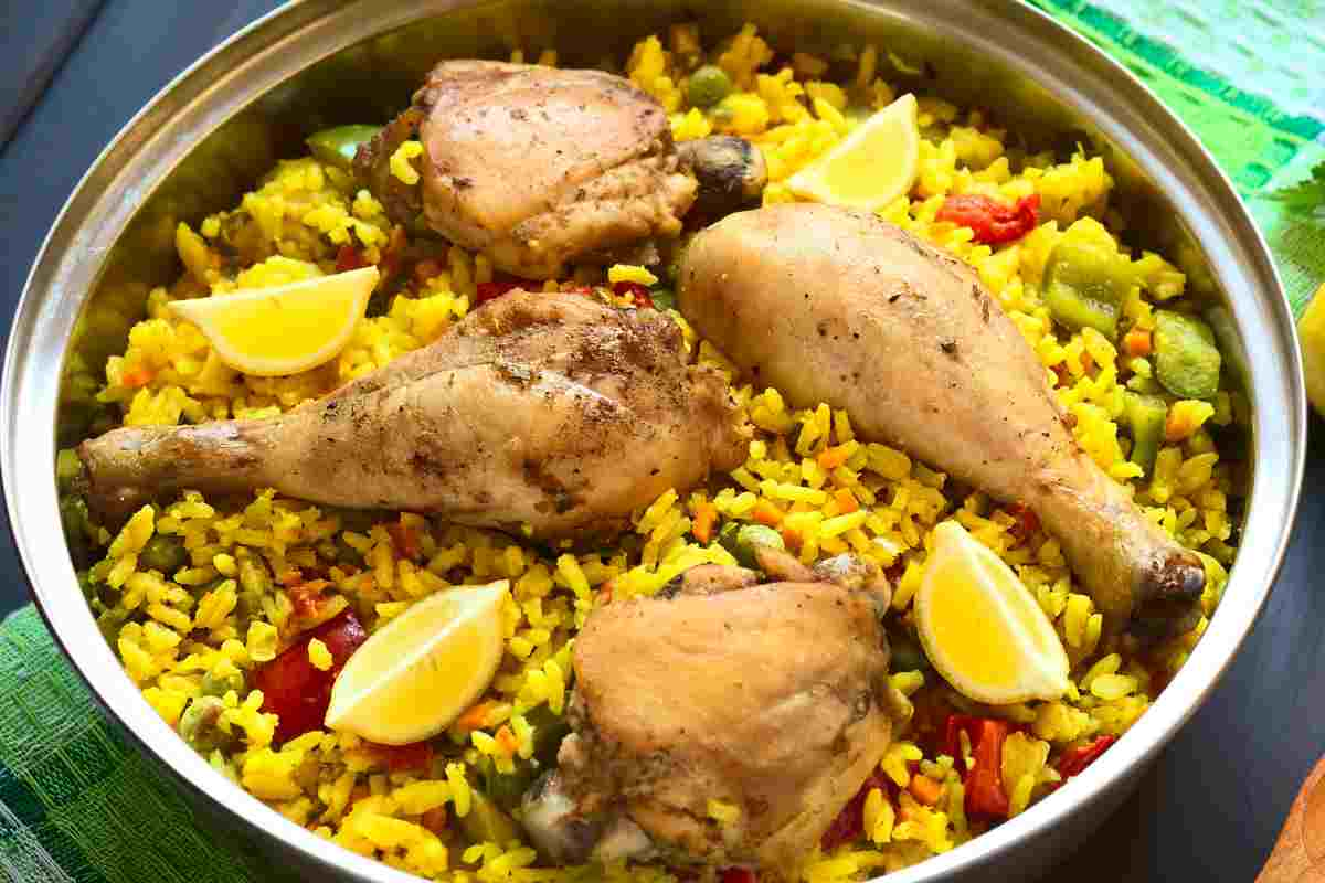 Paella con il pollo e le verdure in una ciotola di metallo