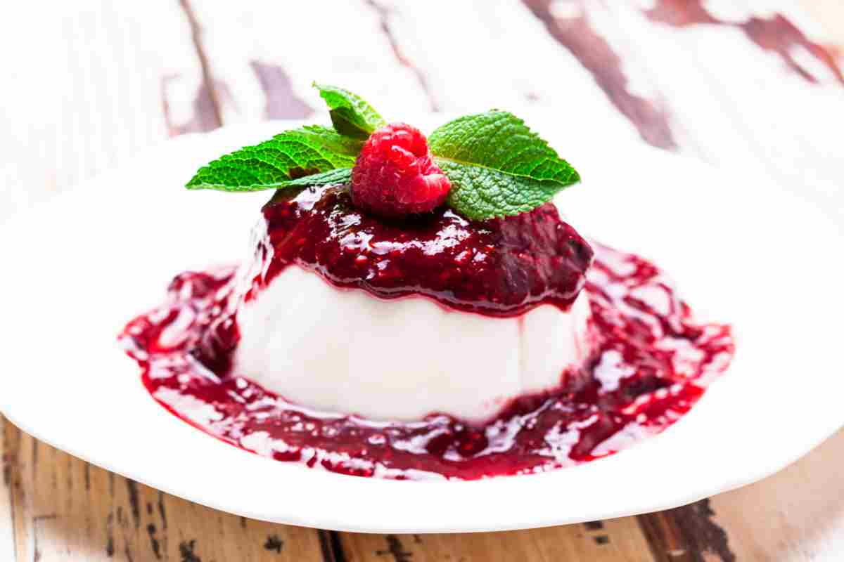 Panna cotta senza panna su un piattino con coulis di lamponi