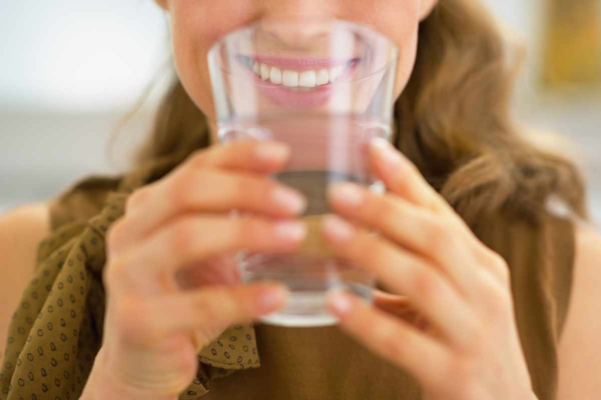 ragazza con bicchiere vicino alla bocca ha problemi a bere acqua, ecco come renderla gustosa