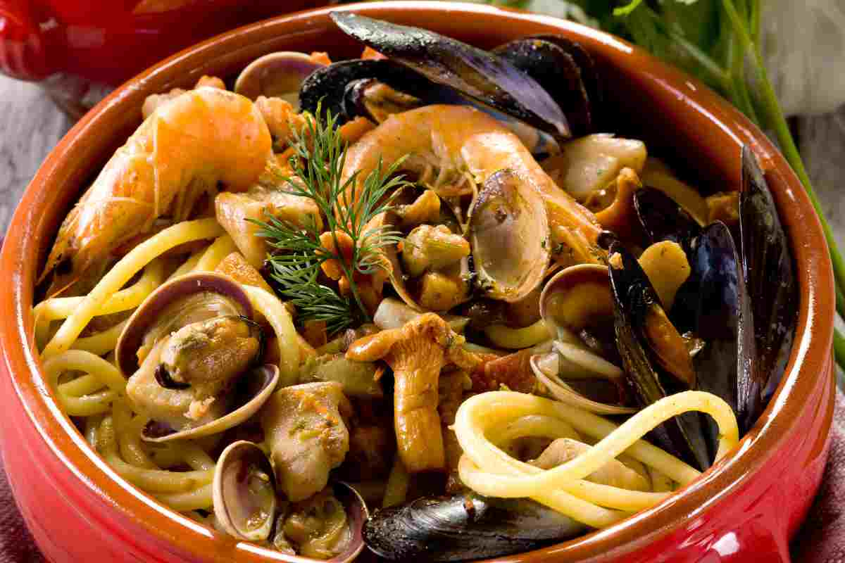 Spaghetti mare e monti in un coccio, il condimento è di frutti di mare e funghi