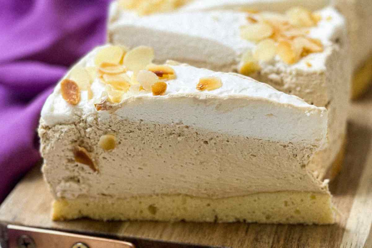 Fette di torta fredda con crema di caffè e panna su un tagliere di legno