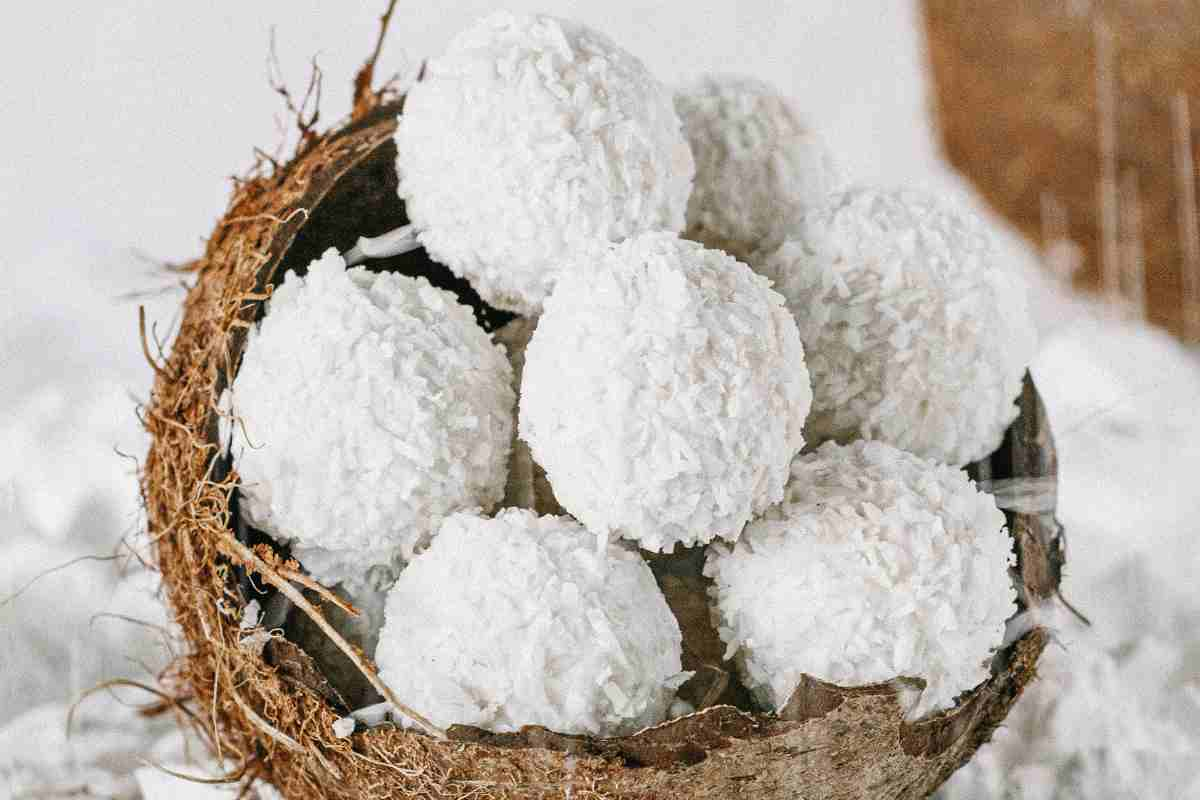 Palline tartufini al cocco in un mezzo guscio di cocco