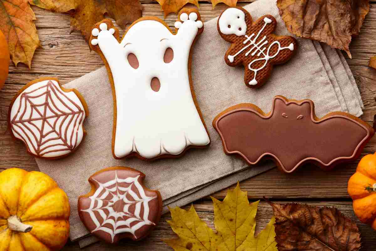 vari tipi di biscotti al cioccolato di Halloween su una tavola con foglie e zucche