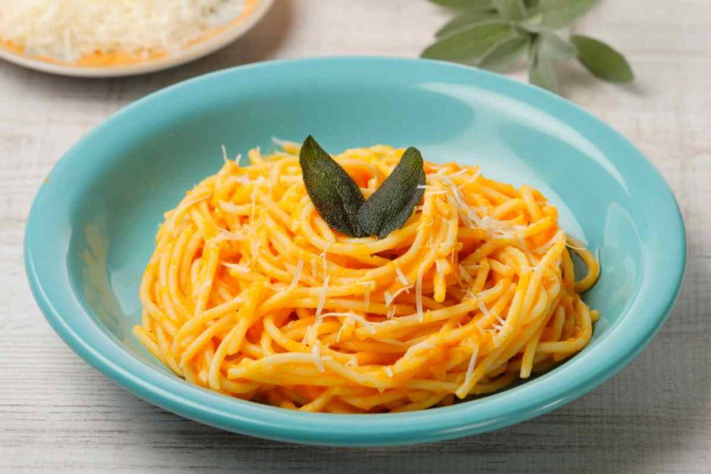 Pasta con la crema di zucca in un piatto fondo azzurro