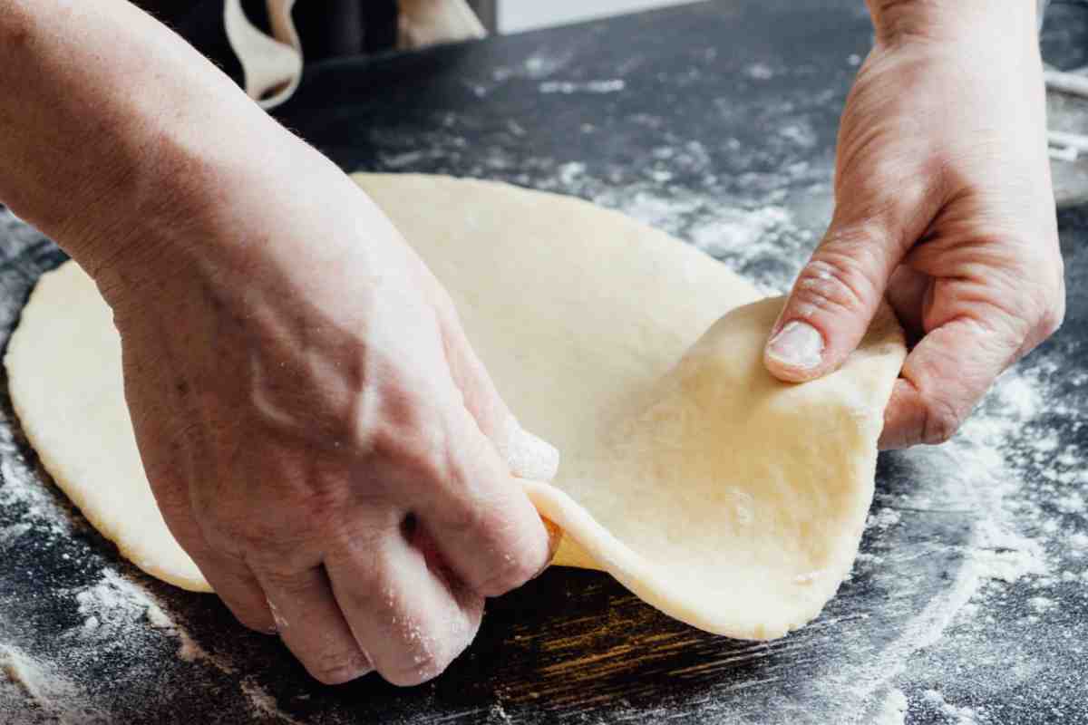 Disco di pasta frolla tra due mani