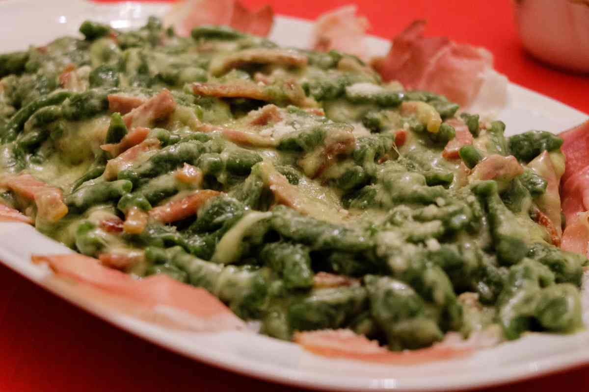 Spätzle agli spinaci e speck in un vassoio