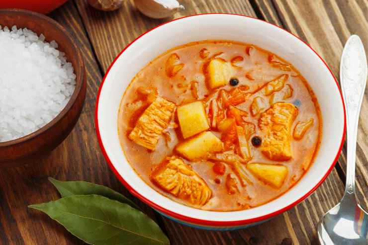 Zuppa di verza e patate con il farro vista dall'alto con vicino due foglie di alloro