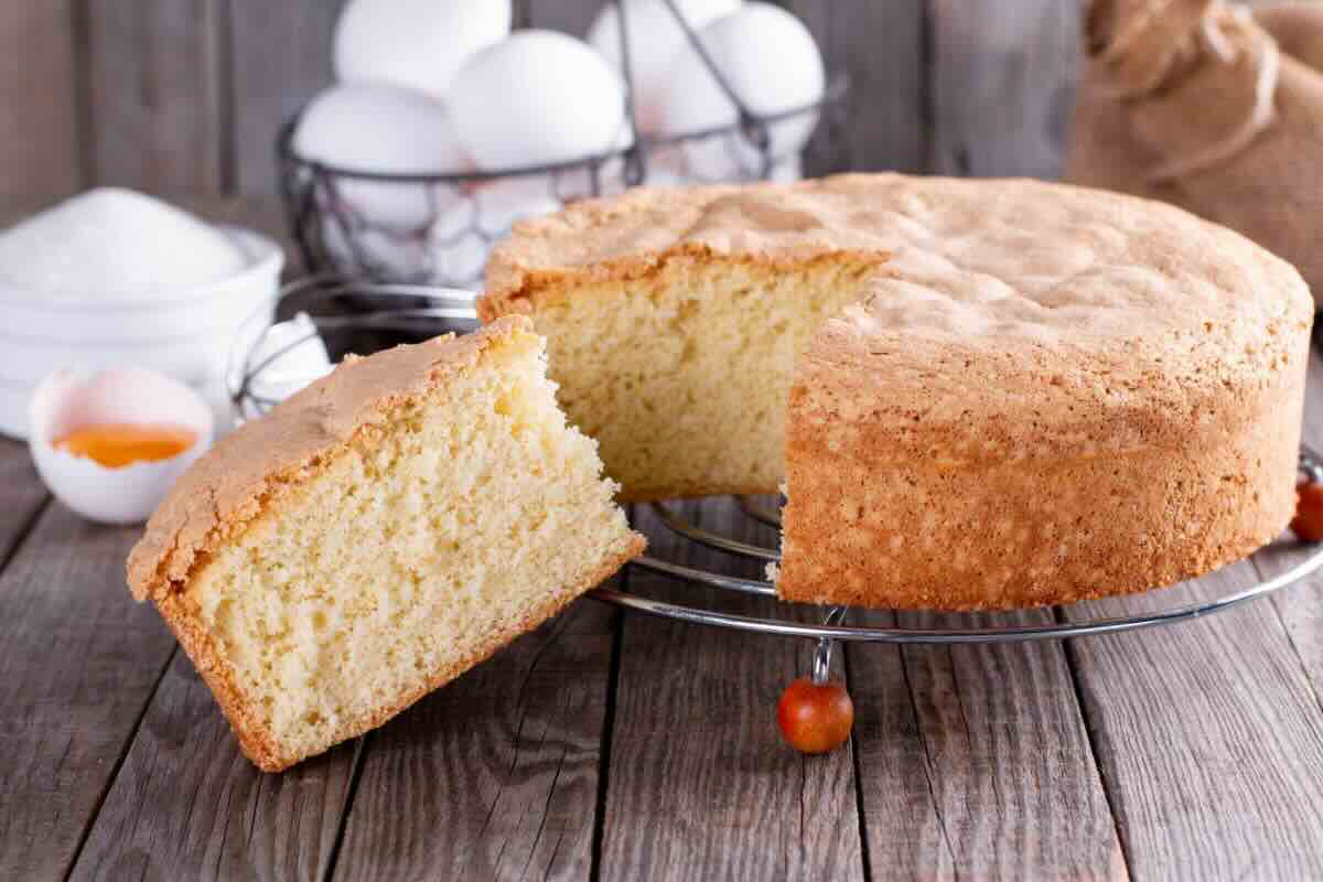 Torta su alzatina, uova sullo sfondo