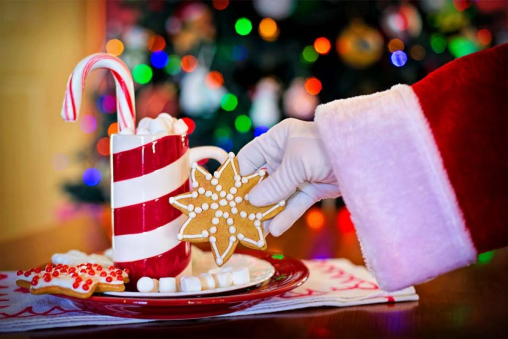 Bicchiere con piattino di Natale, cannuccia in vetro a forma di bastoncino e biscotti