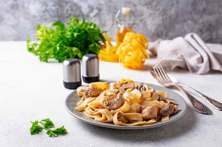 Fettuccine con pollo e funghi su una tavola