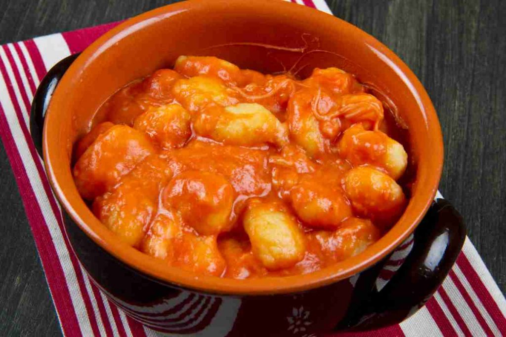 Gnocchi alla sorrentina con ragù napoletano in un tegame di coccio