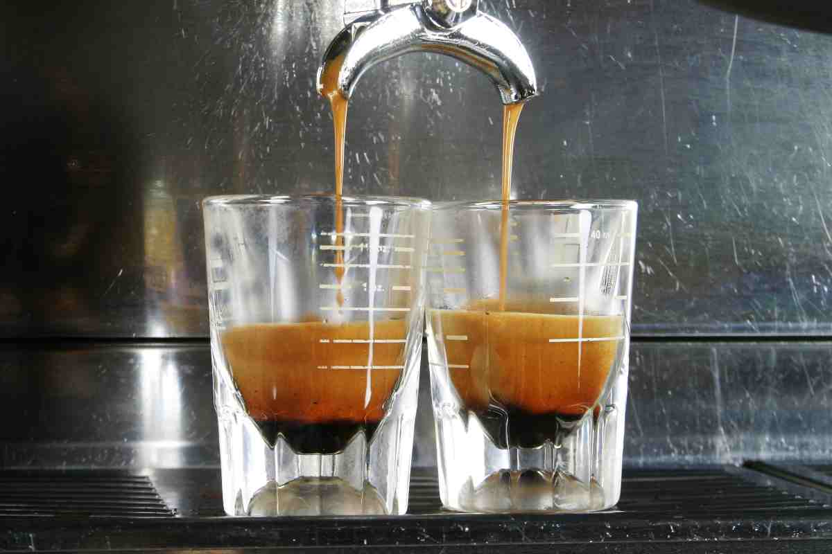 caffè esce da macchinetta in due bicchierini