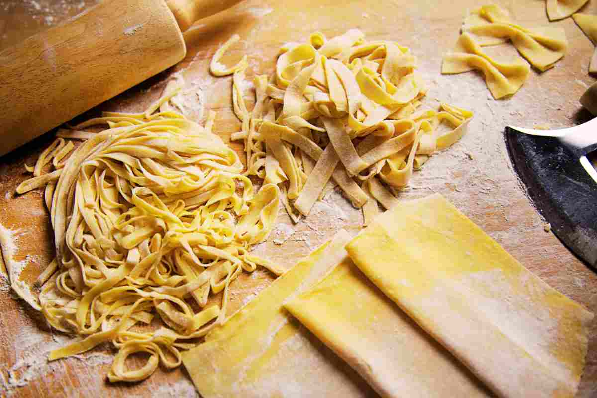 Pasta fresca all'uovo di diverso tipo su una spianatoia