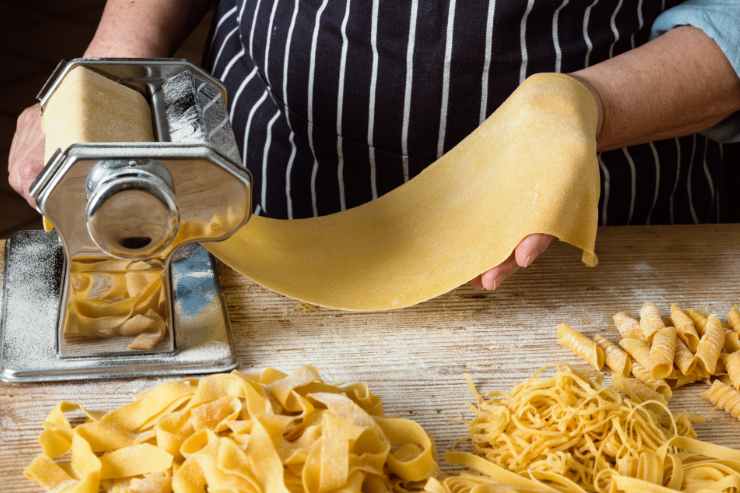 sfoglia all'uovo che passa attraverso la macchinetta la pasta