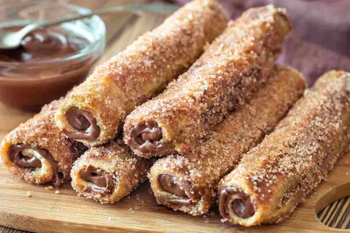 Rotolini di pane fritto alla Nutella su un tagliere