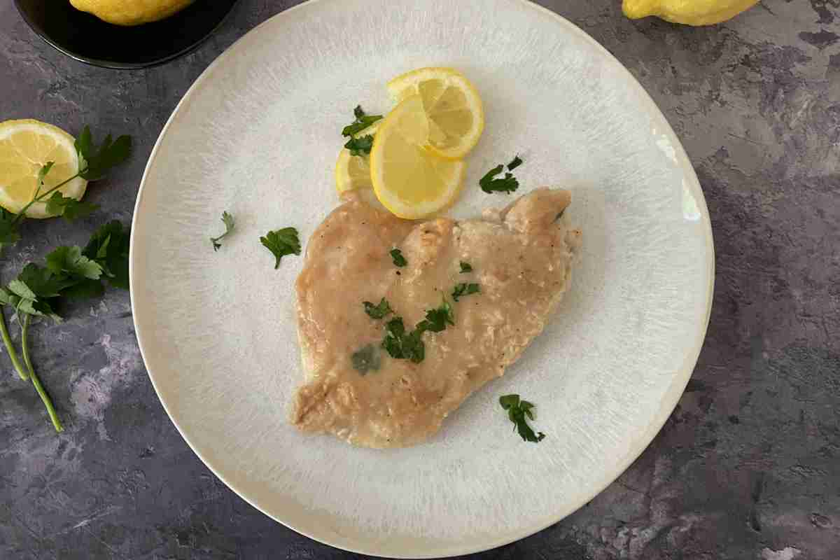 Scaloppina al limone in un piatto vista dall'alto