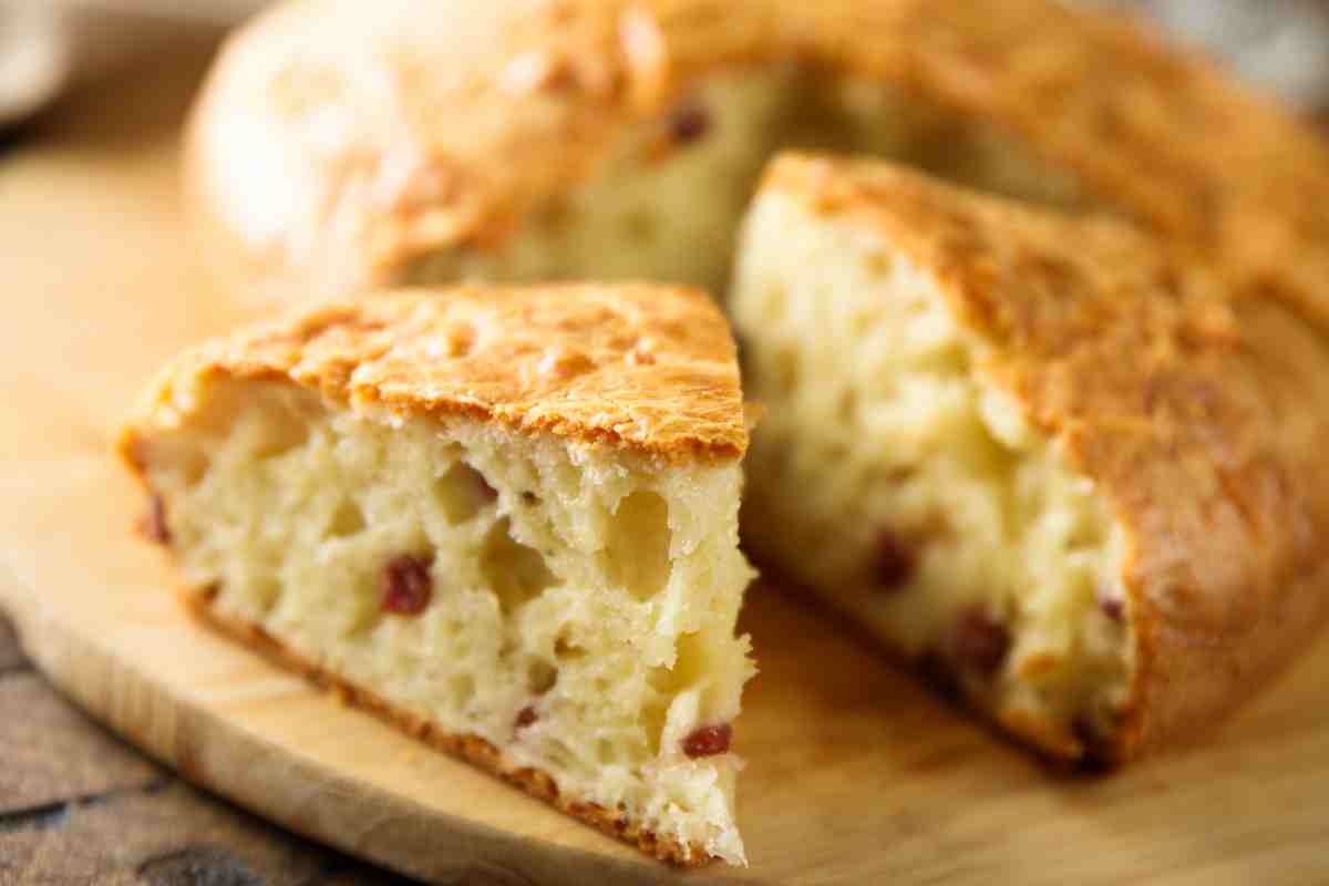 fette di torta salata con prosciutto e scamorza su un tagliere di legno