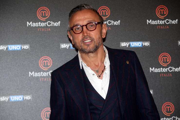 Bruno Barbieri sorride dietro il poster di MasterChef