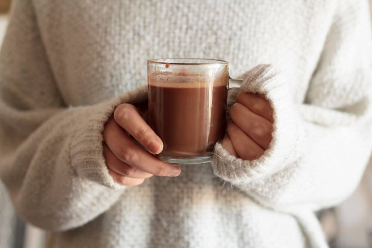 Mani con tazza con cioccolata calda