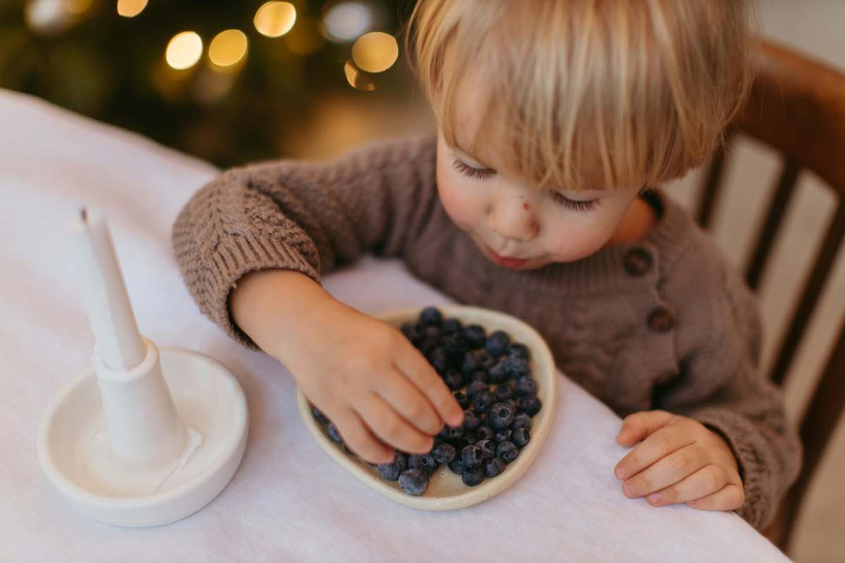 bambino che mangia mirtilli