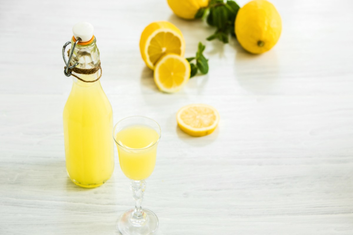 bottiglia e bicchiere di limoncello con limoni