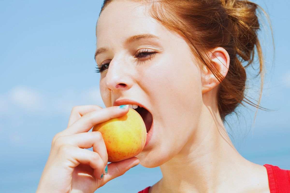 Ragazza che mangia una mela