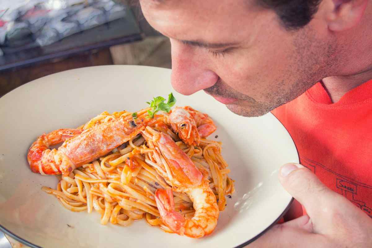 uomo pasta con i gamberi