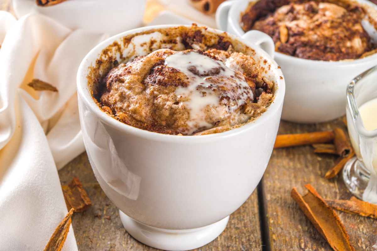 mug cake alla cannella sul tavolo e altri ingredienti